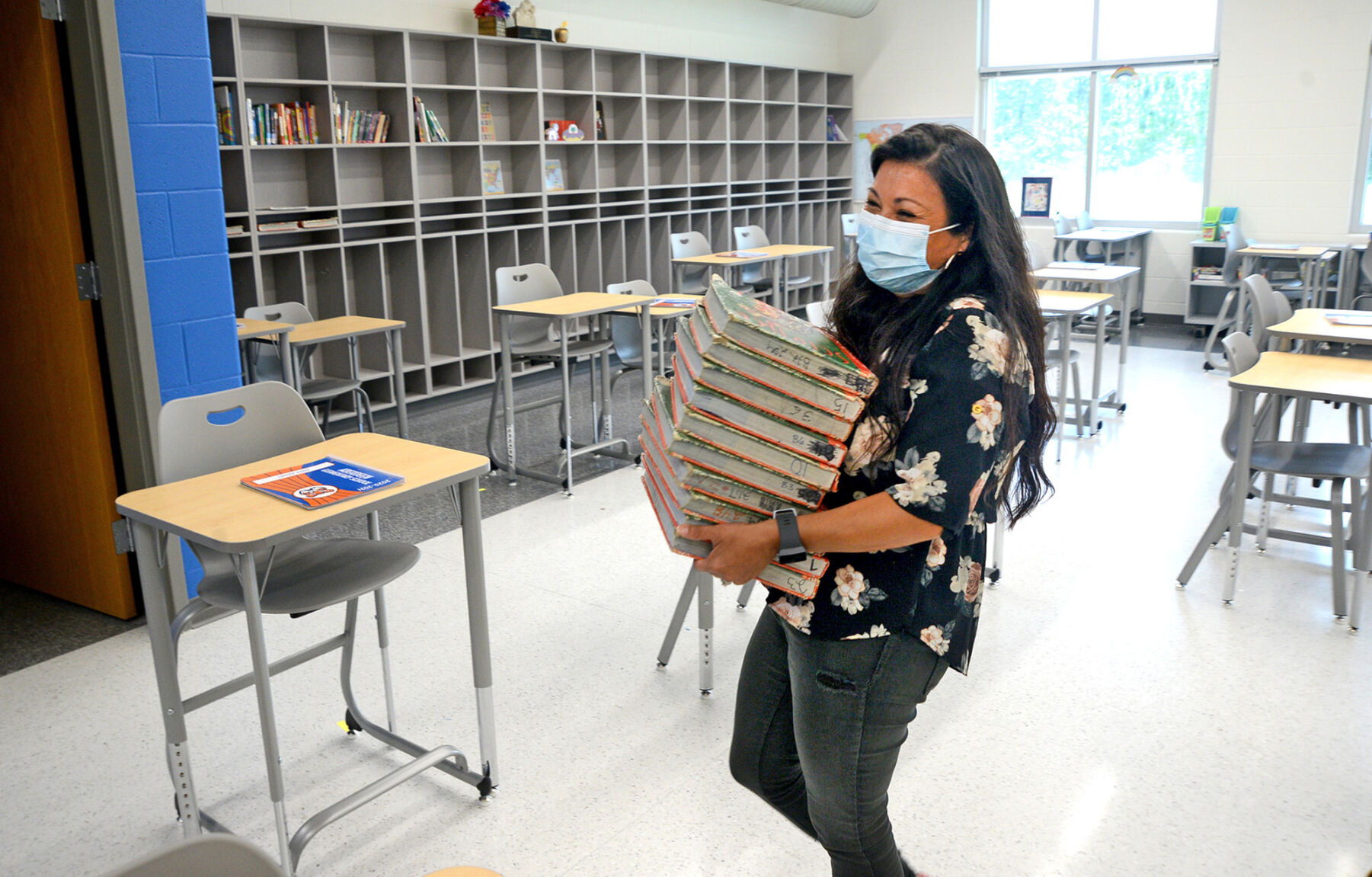 Candace Necochea carries a stack of textbooks